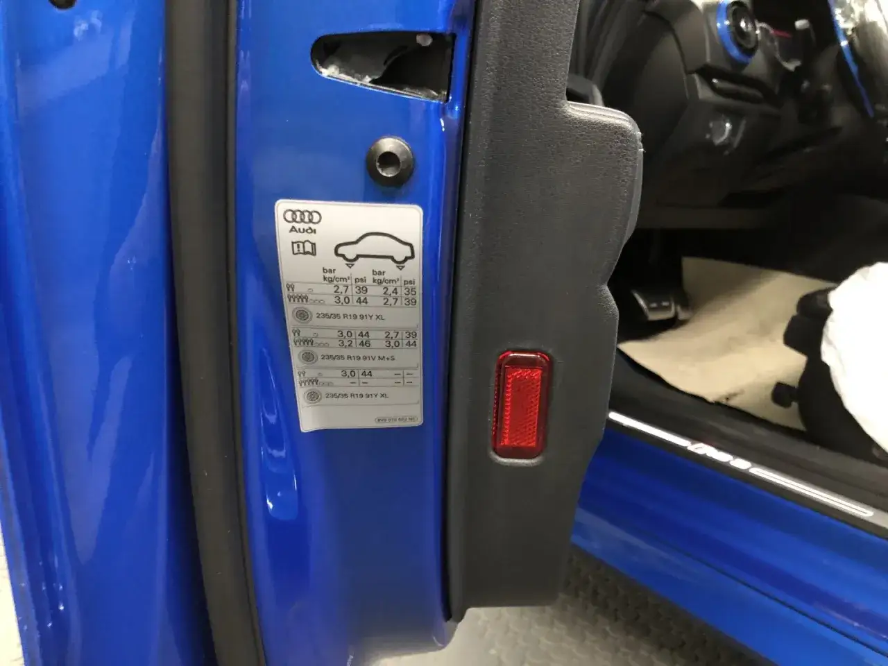 Etichetta sul montante dell'auto Audi con indicazioni sulla pressione pneumatici auto per diverse condizioni di carico e misure di cerchi.