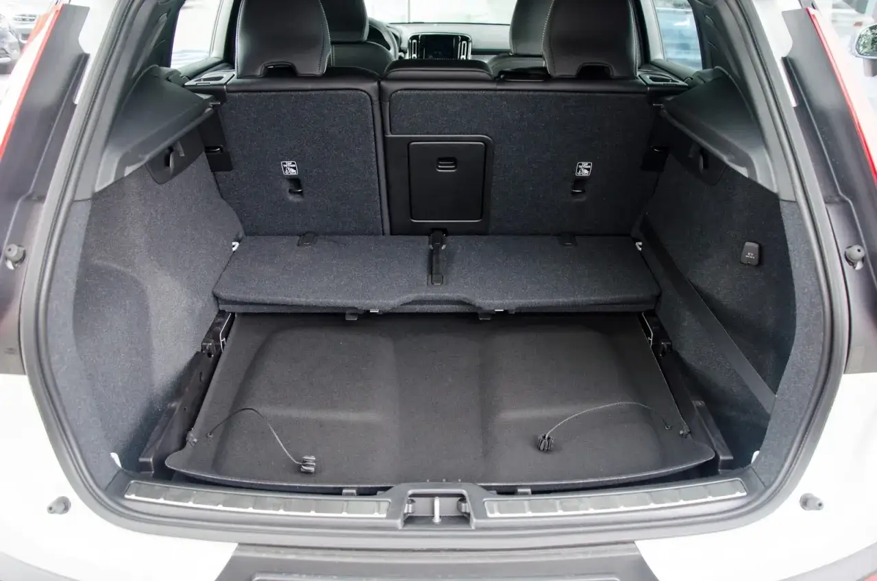 Pusta przestrzeń bagażowa Volvo XC40, z podniesioną podłogą, pokazuje jego praktyczne wymiary.