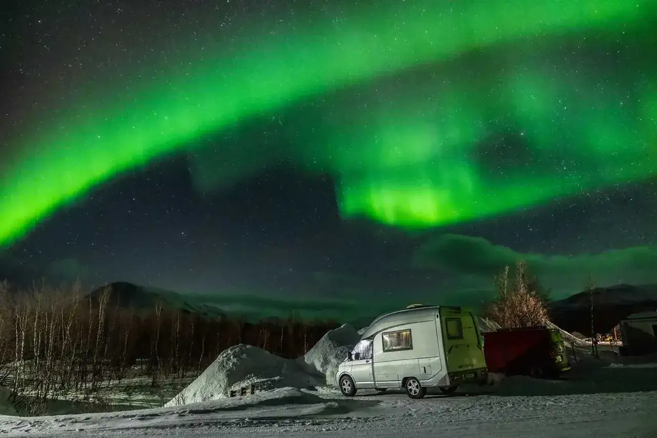 Gr&ouml;n norrsken dansar &ouml;ver en sn&ouml;ig finsk natt. En husbil st&aring;r parkerad, redo f&ouml;r &auml;ventyr under stj&auml;rnorna.