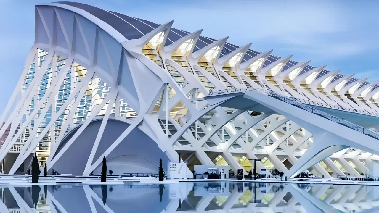 El Hemisfèric, parte del museo della scienza valencia, se refleja en el agua, con su arquitectura futurista y sus luces encendidas.