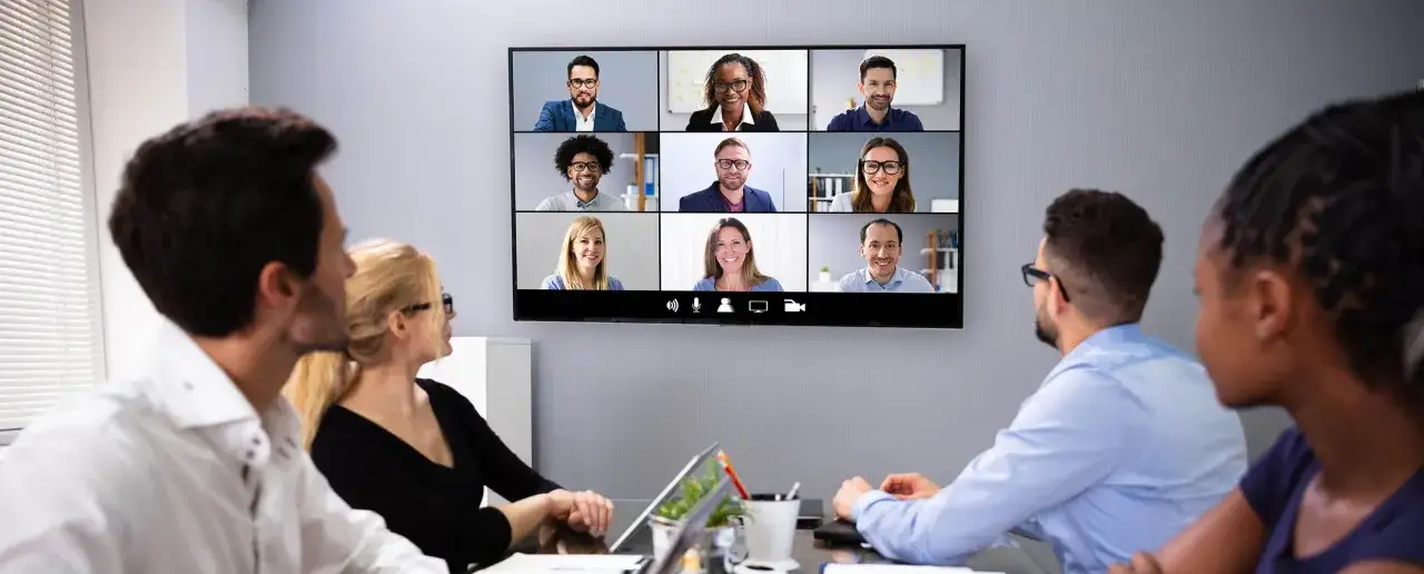 Ein Team bespricht sich per Video-Konferenz. Was ist ein Manager? Jemand, der das Team leitet und motiviert, wie die Personen auf dem Bildschirm.