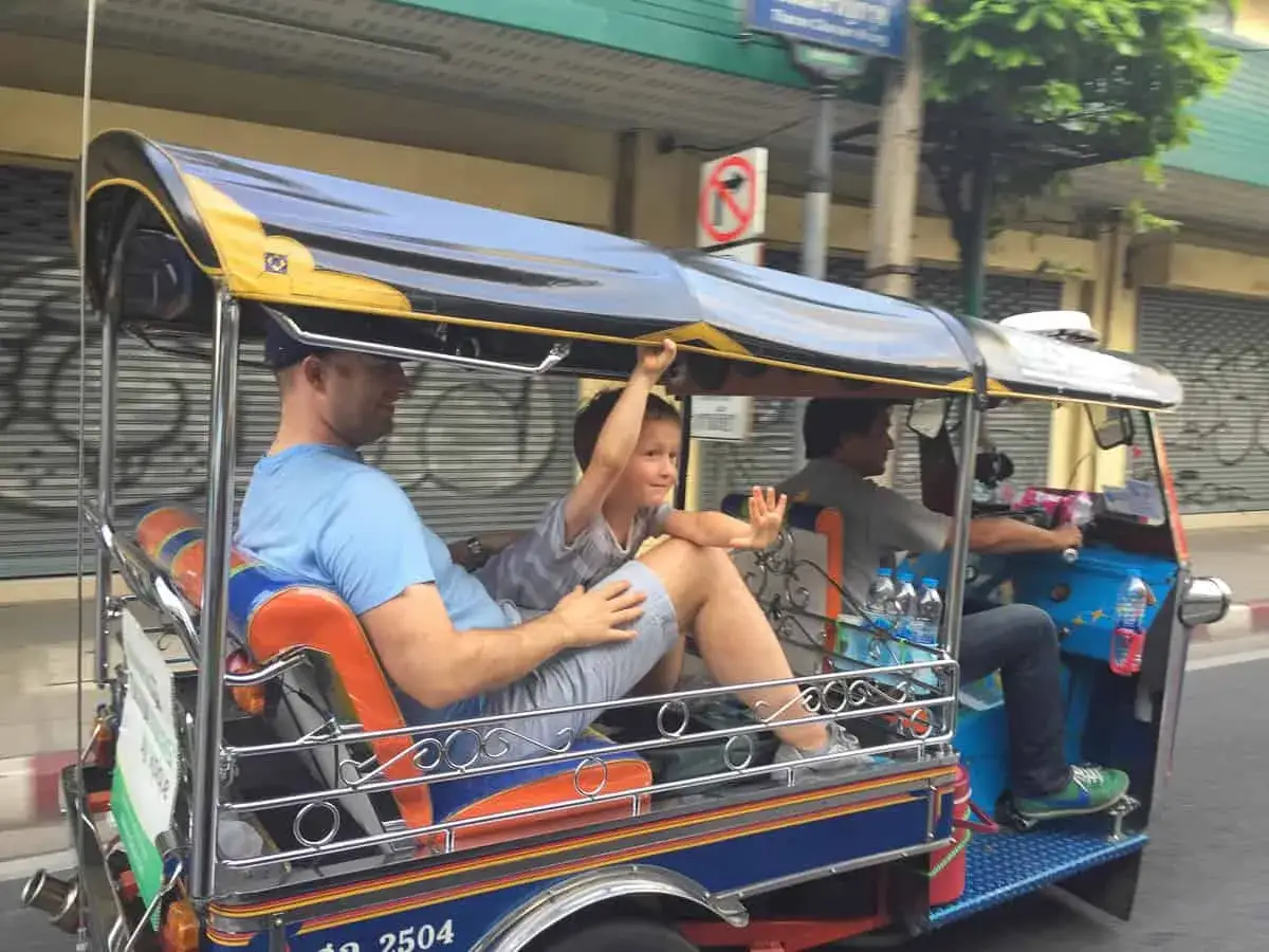 Rodzina cieszy się przejażdżką tuk-tukiem, doświadczając autentycznego transportu w Bangkoku.