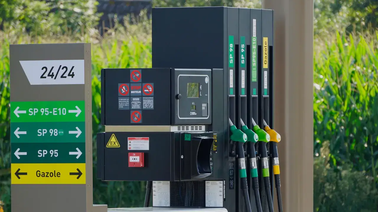 Pompe &agrave; essence avec plusieurs carburants disponibles, dont le SP95-E10. Panneau indiquant les directions pour SP95-E10, SP98, SP95 et Gazole.