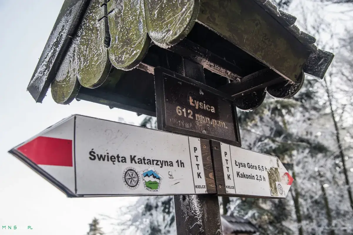 Zimowy szlak na Łysicę. Tabliczka kierunkowa wskazuje drogę do Świętej Katarzyny i na Łysą Górę.