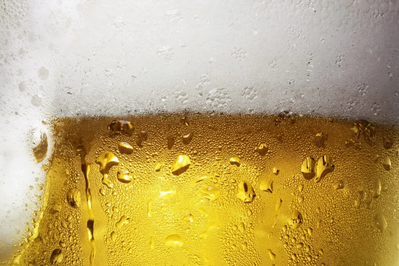 Zimne piwo z pianką, krople na szkle. Czy picie piwa z puszki zmienia jego smak? Mit a rzeczywistość.