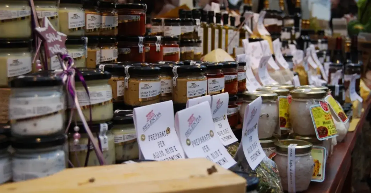Vasi di conserve e prodotti tipici, un tripudio di sapori per le sagre tartufo toscana.
