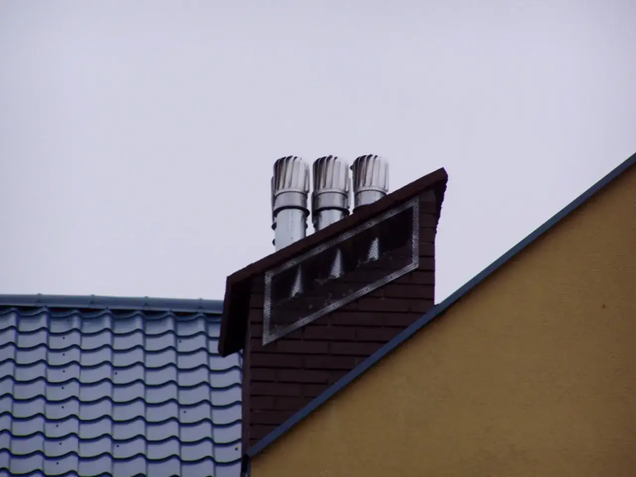 Trzy obrotowe nasady kominowe zamontowane na ceglanym kominie, zapewniające prawidłowy montaż i wentylację.