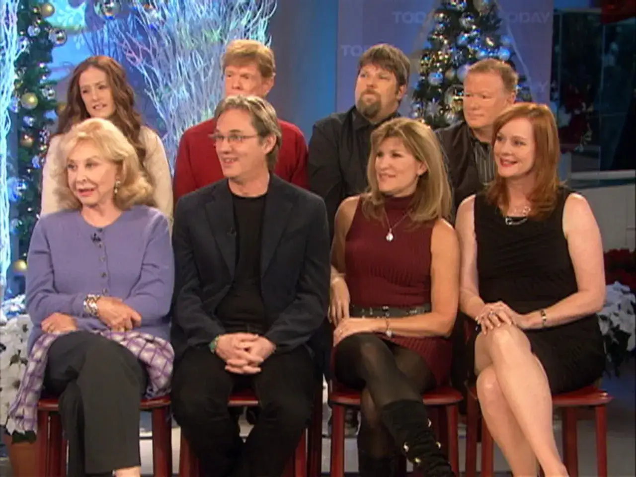Die Besetzung von Die Waltons sitzt f&uuml;r ein Interview vor Weihnachtsb&auml;umen.