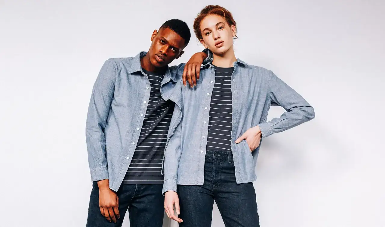 Modelo andrógina y un hombre posan con camisas vaqueras y camisetas a rayas.