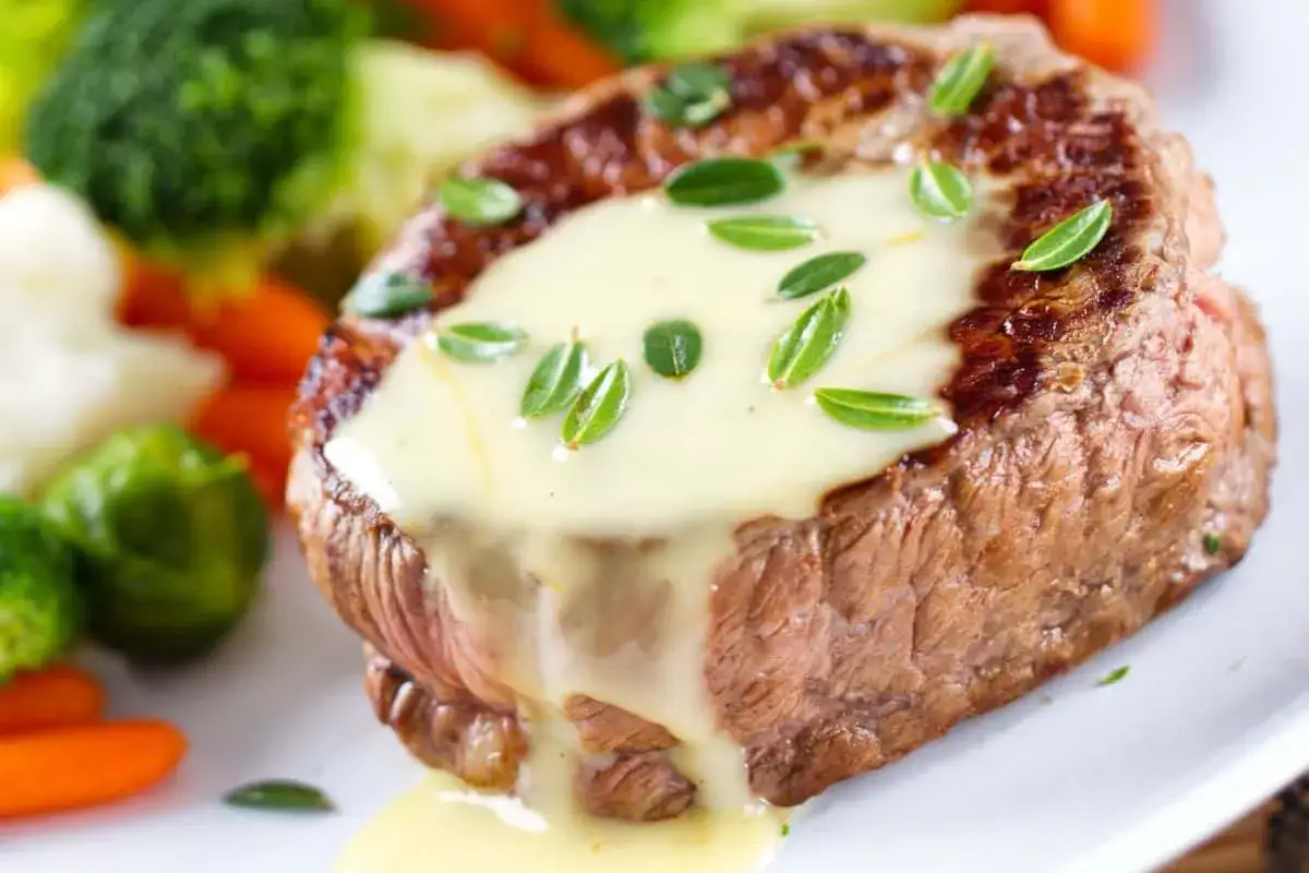 Un steak tendre napp&eacute; d'une onctueuse sauce b&eacute;arnaise, accompagn&eacute; de l&eacute;gumes verts et de carottes.