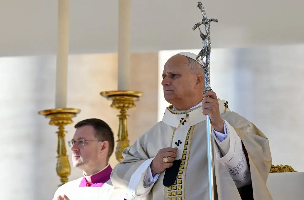 Papież z pastorałem, w białej szacie z ozdobnym kołnierzem, wygłasza credo. Obok niego kleryk.