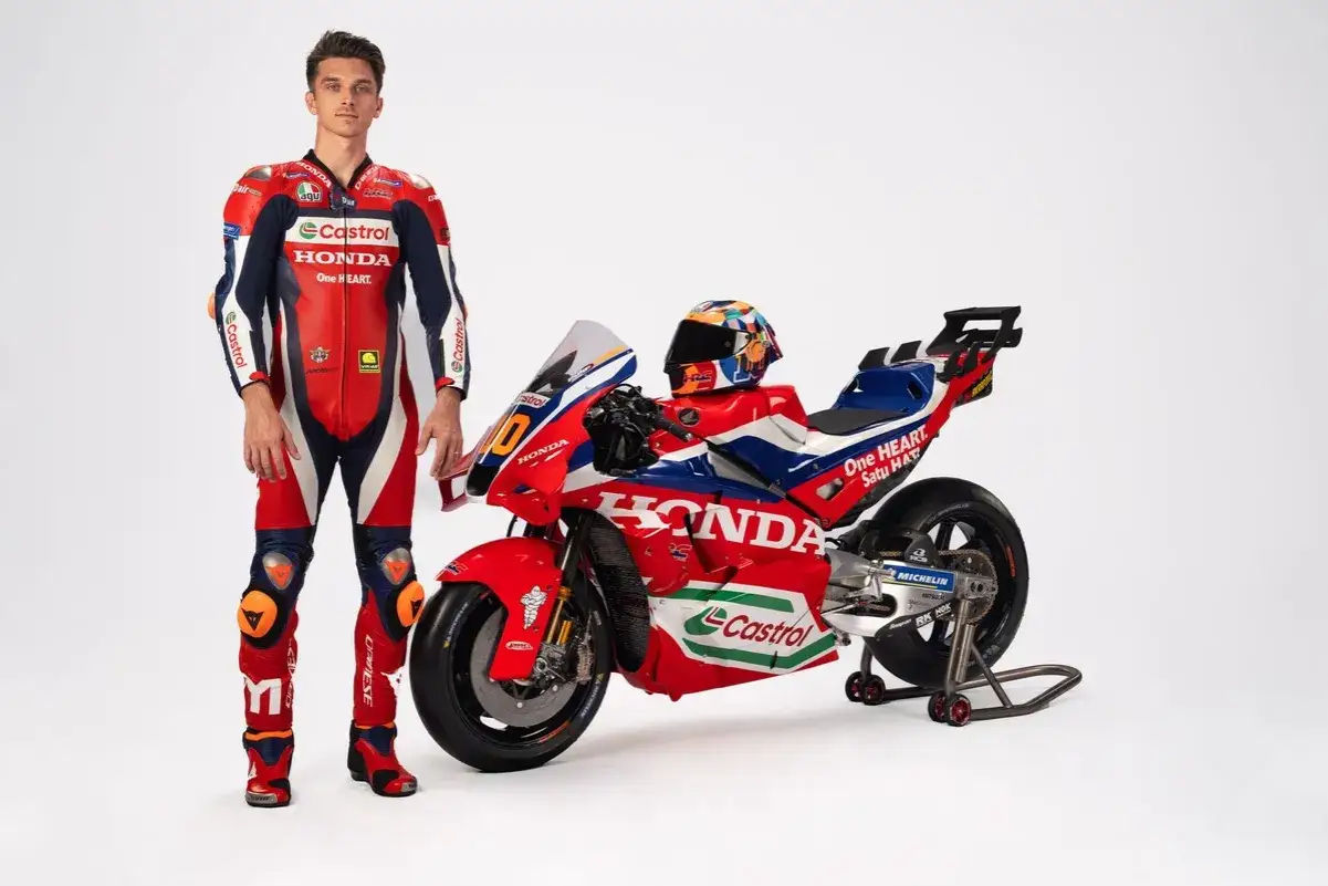 Luca Marini posa junto a su moto Honda de competici&oacute;n, luciendo su traje de piloto rojo, blanco y azul.