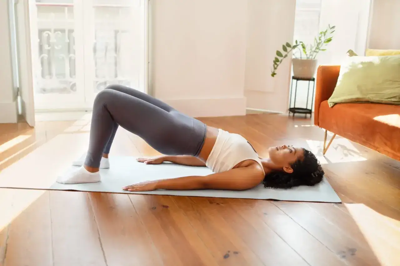 Femme effectuant un pont, exercice doux pour la convalescence après opération d'un prolapsus.