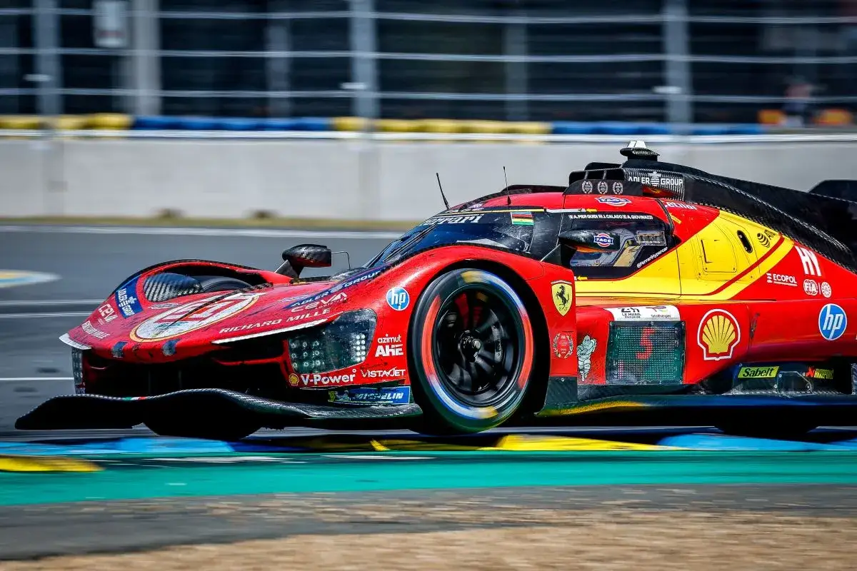 Un coche de carreras rojo y amarillo de Le Mans, con el n&uacute;mero 5, acelera en la pista.