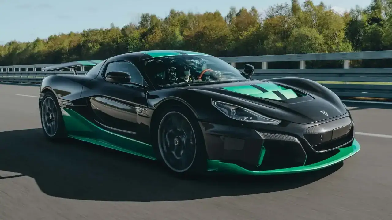 Schwarzer Rimac Nevera mit grünen Akzenten auf der Rennstrecke, bereit für seine Höchstgeschwindigkeit.