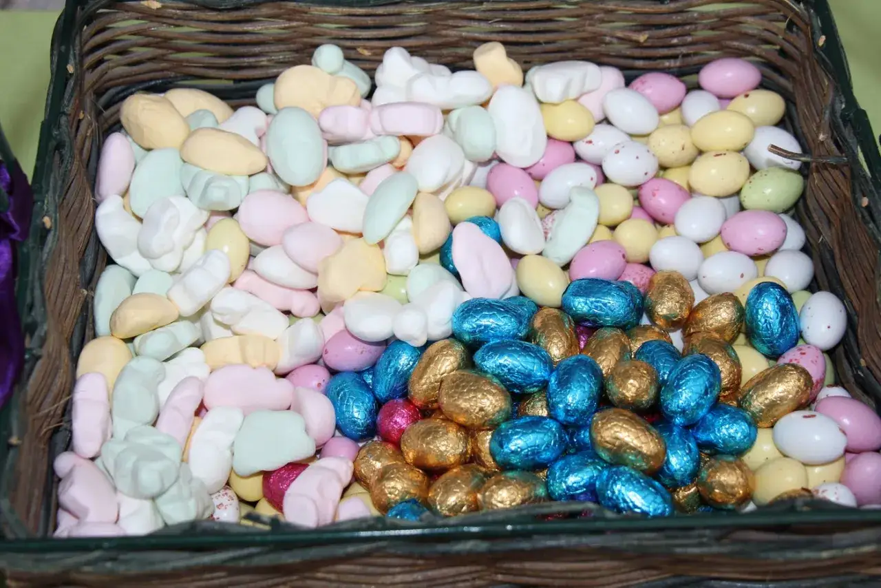 En korg fylld med p&aring;skgodis, inklusive marshmallows i pastellf&auml;rger och choklad&auml;gg i folie. Detta &auml;r en del av vad som betyder p&aring;sk f&ouml;r m&aring;nga.