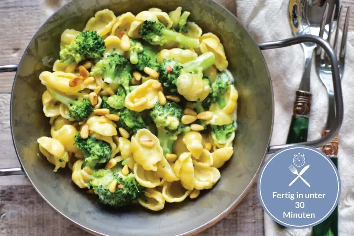 Pasta mit Brokkoli und Pinienkernen, ein schnelles italienisches Gericht, serviert in einer Metallsch&uuml;ssel.