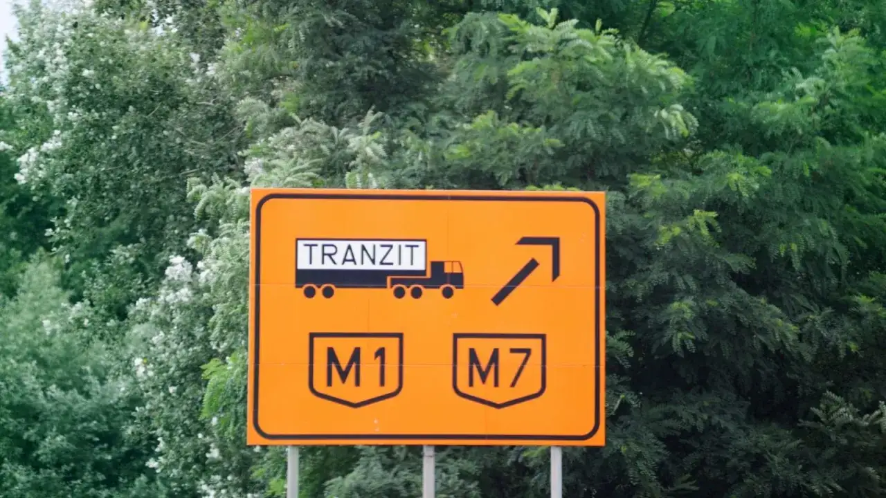 Pomarańczowy znak drogowy na Węgrzech informuje o tranzycie i drogach M1, M7. Uważaj na mandat za brak winiety!