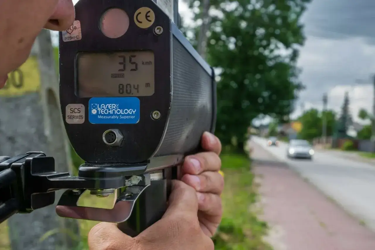 Ręczny radarowy pomiar prędkości pokazuje 35 km/h. Urządzenie mierzy odległość 80.4 m do celu.