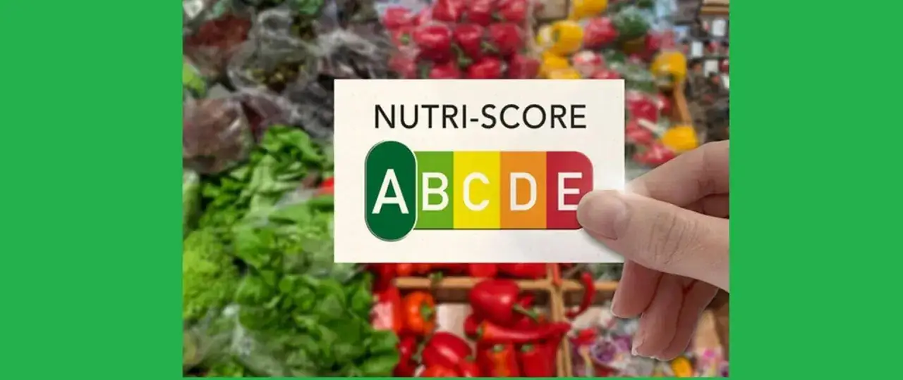 Karta z systemem nutri-score, gdzie litera D jest widoczna, na tle świeżych warzyw.