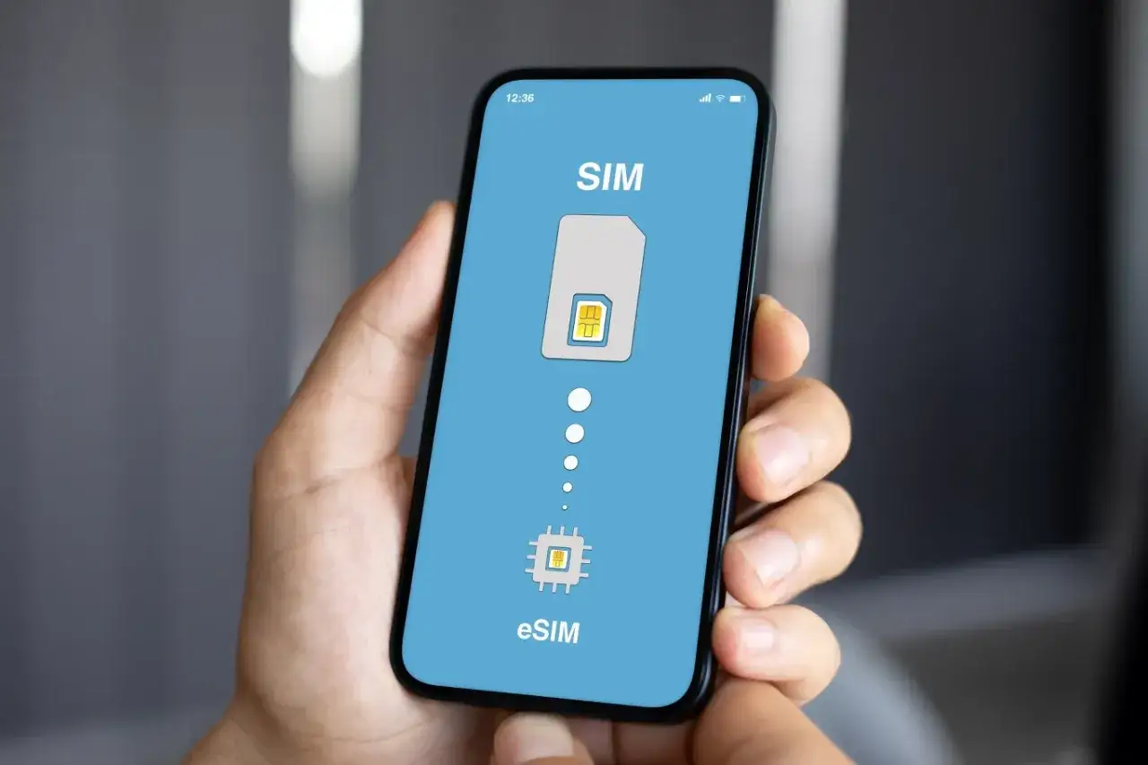 Dłoń trzyma smartfon z ekranem pokazującym proces aktywacji karty eSIM. Idealne rozwiązanie na podróż do Turcji.