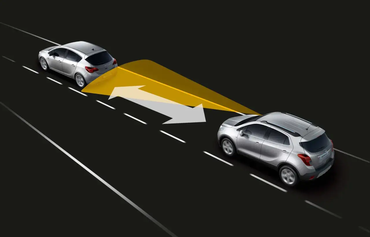 Dos coches plateados en una carretera. El coche de atrás emite un haz amarillo y flechas que indican la **distancia de seguridad** con el coche de delante.