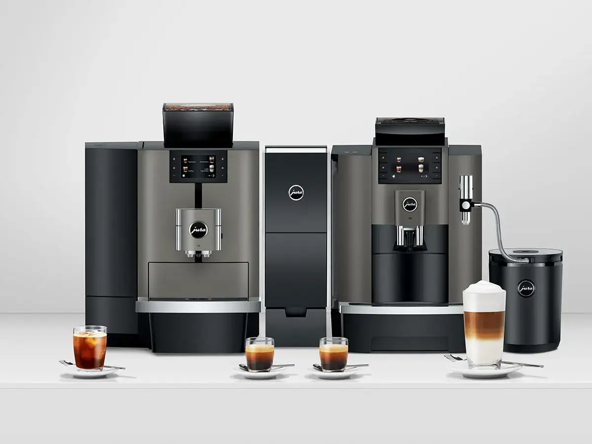 Dwa eleganckie ekspresy do firmy Jura, gotowe do przygotowania idealnej kawy. Obok nich filiżanki z aromatycznym espresso i latte.