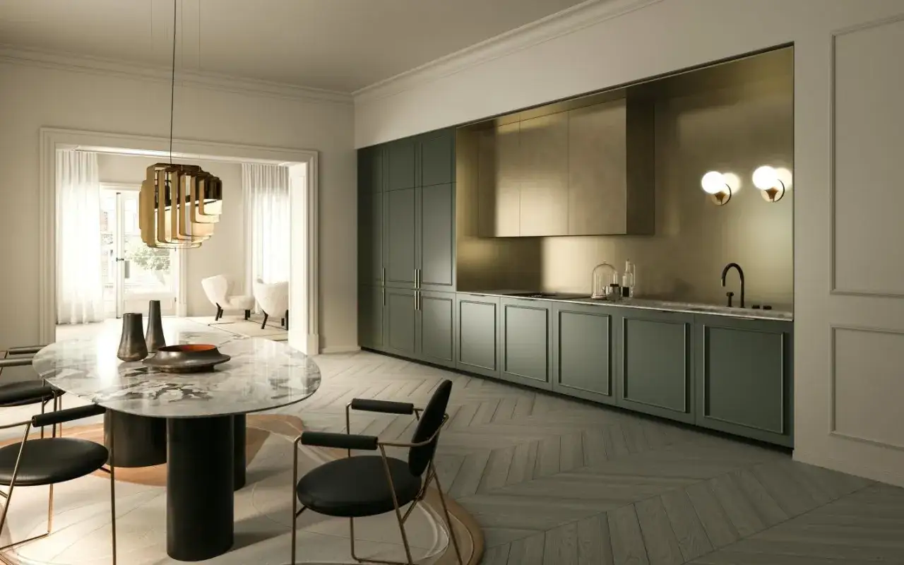 Cucina moderna con mobili verde bosco colore, piano in marmo e lampadario dorato. Tavolo ovale con sedie nere.