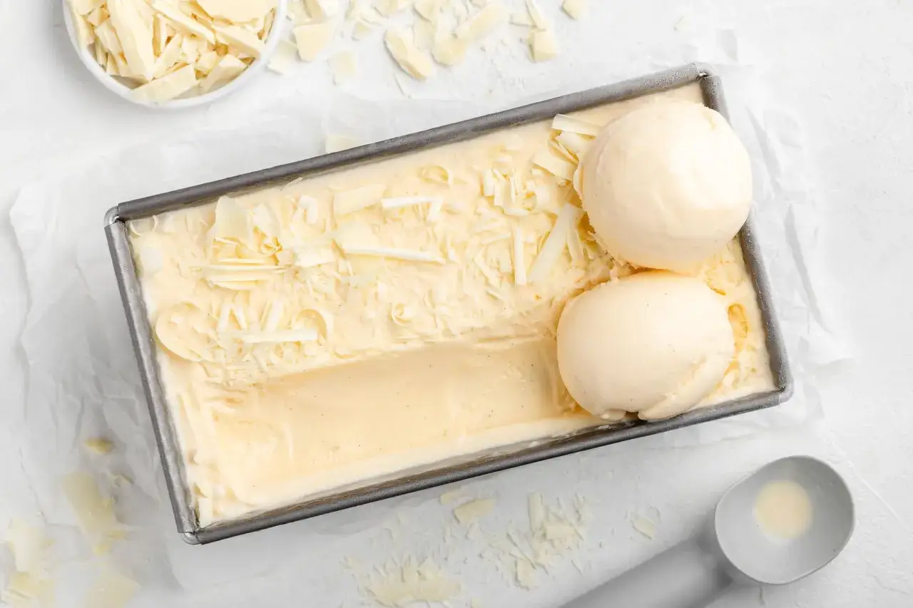 Cremiges Vanilleeis mit Schokoladenraspeln, frisch aus der Eismaschine, bereit zum Servieren.