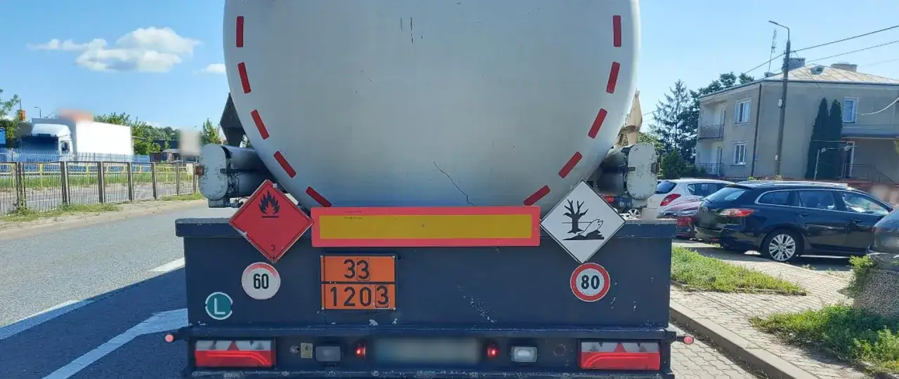 Cysterna z oznaczeniami transportu ADR. Widoczne tablice z numerami 33 i 1203, symbol łatwopalności i zagrożenia dla środowiska.