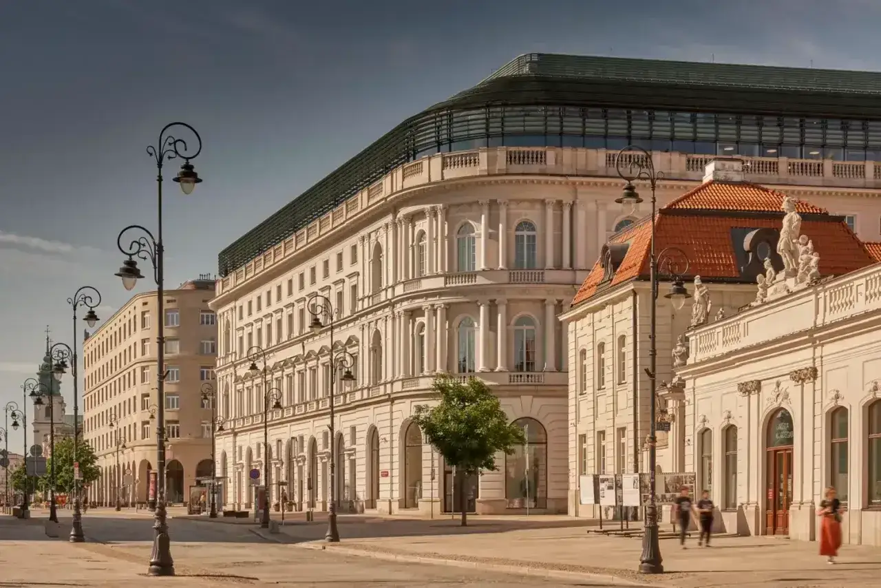 Elegancka kamienica z nowoczesnym dachem, przypominająca najdroższy hotel w Polsce, stoi przy pustej ulicy.