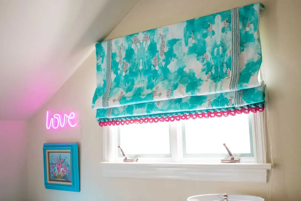 Bright teal roman shades with a playful pink trim, a perfect DIY project for adding color.