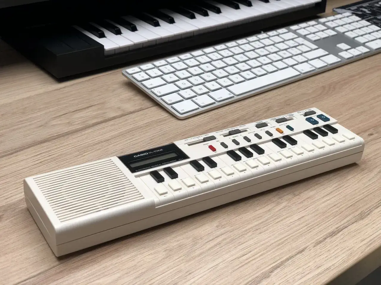 Clavier Casio VL-Tone, parfait pour un test oreille absolue sans conna&icirc;tre les notes. Un clavier blanc sur un bureau en bois.