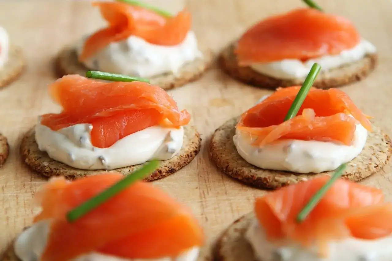 Deliziosi crostini con salmone affumicato, formaggio cremoso e erba cipollina. Un antipasto perfetto, quasi come un salmone in gravidanza, pronto per essere gustato.