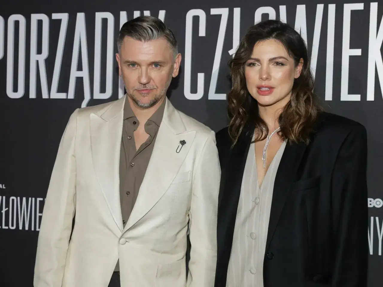 Krzysztof Czeczot z żoną na premierze. Elegancka para pozuje na tle napisu