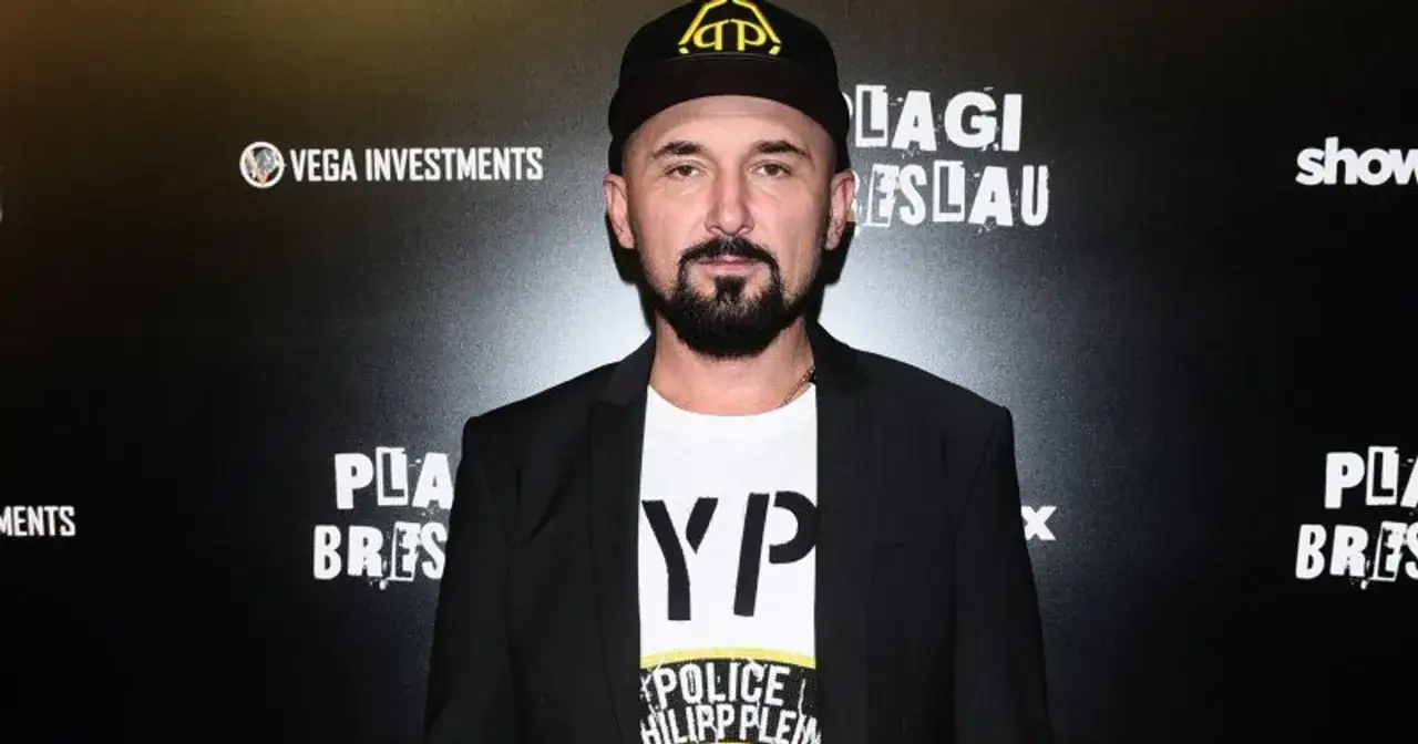Patryk Vega na tle napisów 
