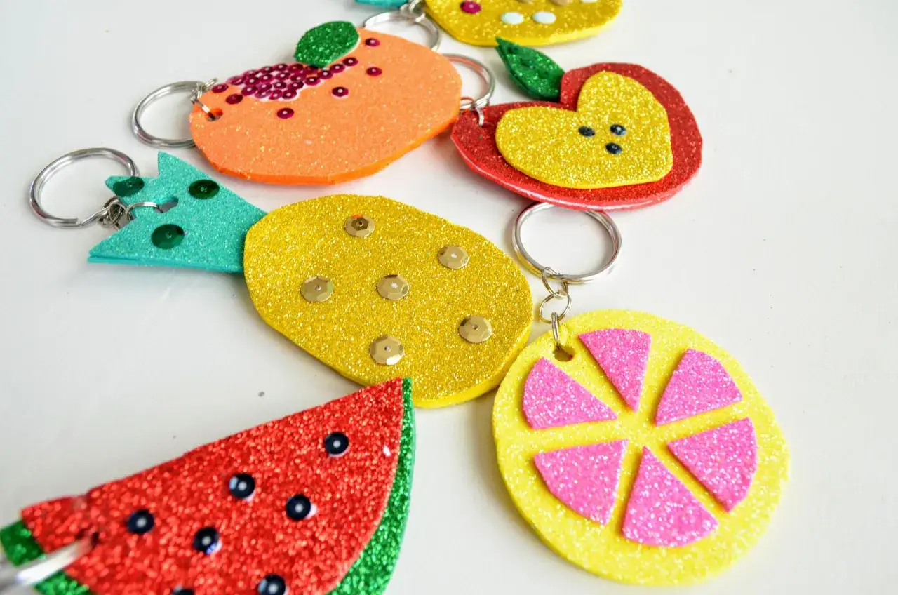 Llaveros de goma eva que son divertidos y brillantes, con formas de frutas como sand&iacute;a, naranja, manzana y lim&oacute;n, decorados con lentejuelas.
