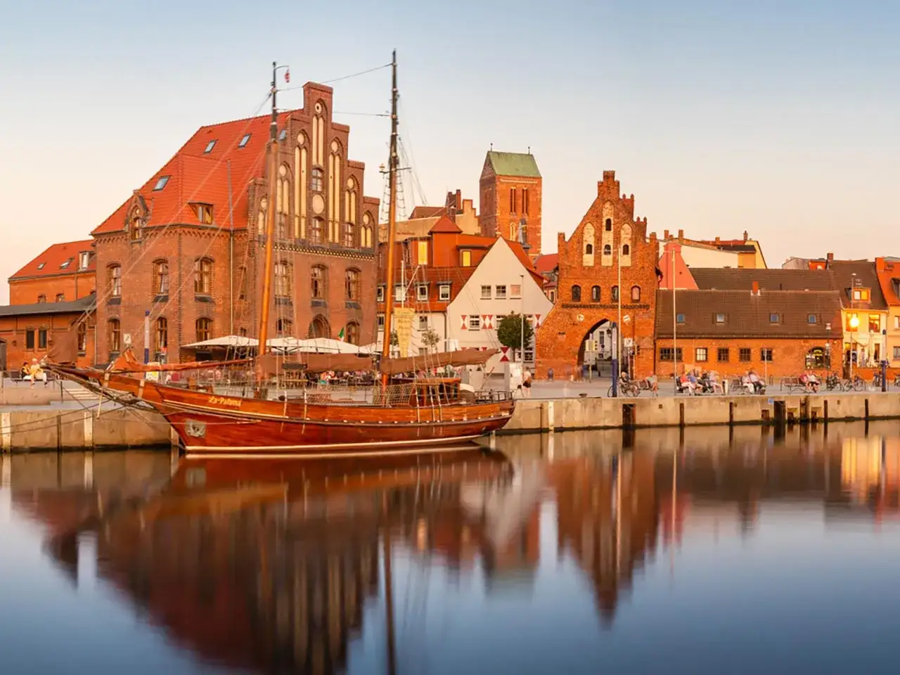 Ein Segelschiff liegt im Hafen von Wismar. Hier kann man die historische Backsteinarchitektur und das maritime Flair genie&szlig;en.