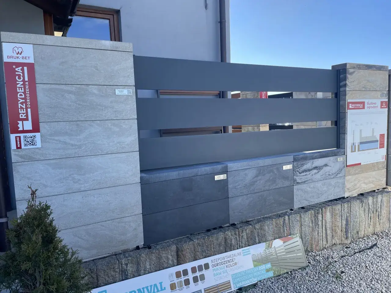 Nowoczesne ogrodzenie z betonowych bloczków w odcieniu RAL 9011, z elementami imitującymi kamień i drewno.