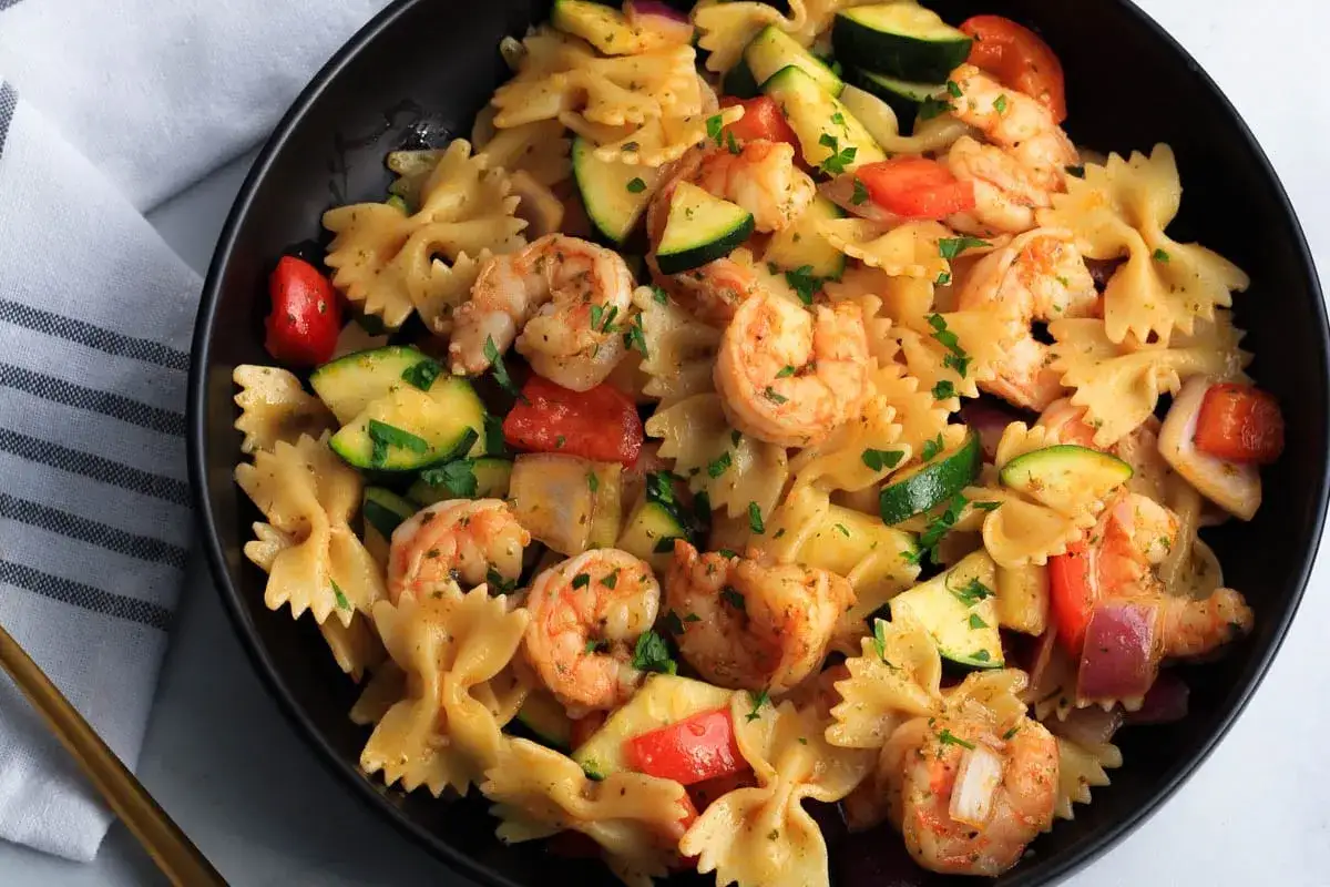 Makaron farfalle z soczystymi krewetkami 16/20, cukinią i pomidorkami.