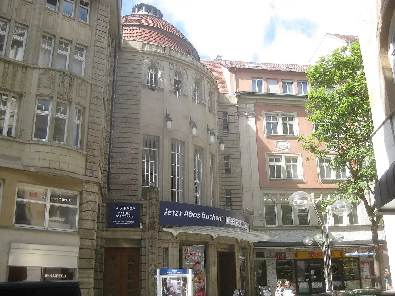 Das alte Theaterhaus Stuttgart mit seiner markanten Kuppel und der Fassade. Ein Schild wirbt f&uuml;r 