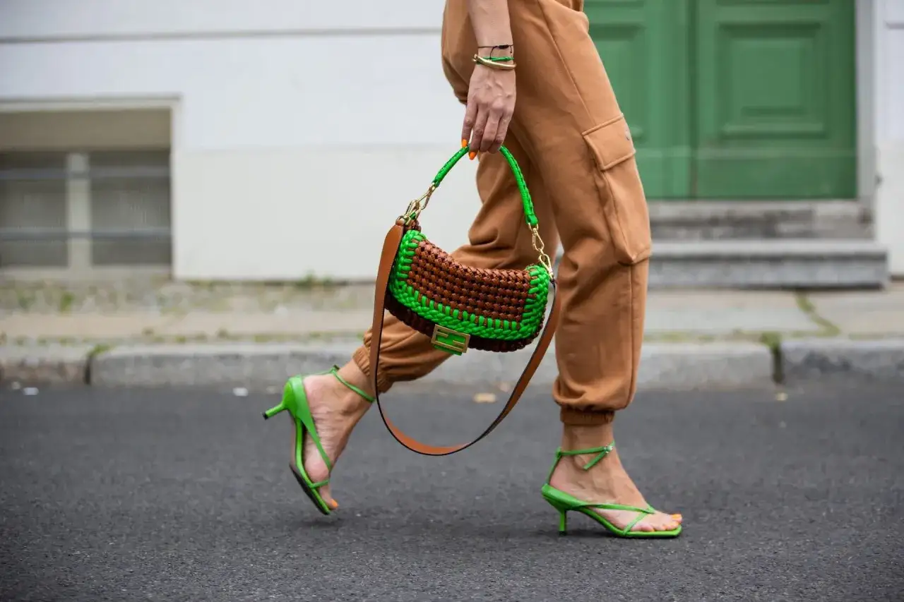 Bolso tejido donde verde y marr&oacute;n combinan a la perfecci&oacute;n, con sandalias a juego y pantalones cargo.