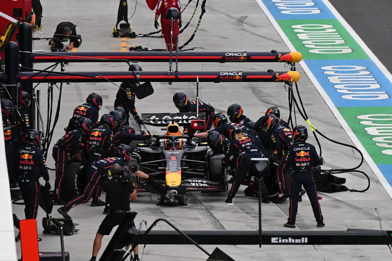 El equipo de Red Bull, con Gianpiero Lambiase observando, realiza un r&aacute;pido cambio de neum&aacute;ticos en un monoplaza de F&oacute;rmula 1.