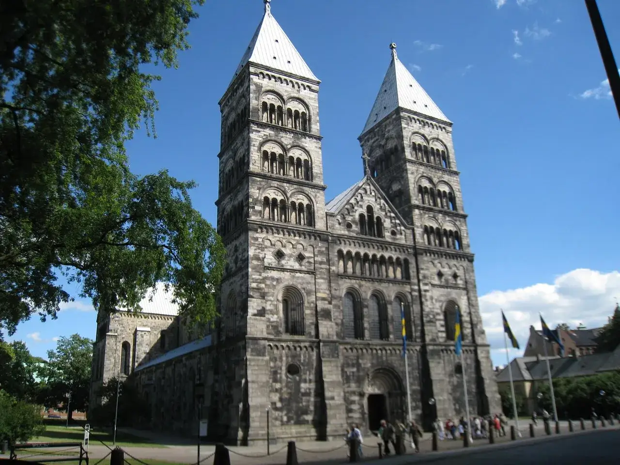 Lunds domkyrka med sina torn. En vacker plats f&ouml;r aktiviteter i Lund f&ouml;r vuxna, med folk som promenerar.