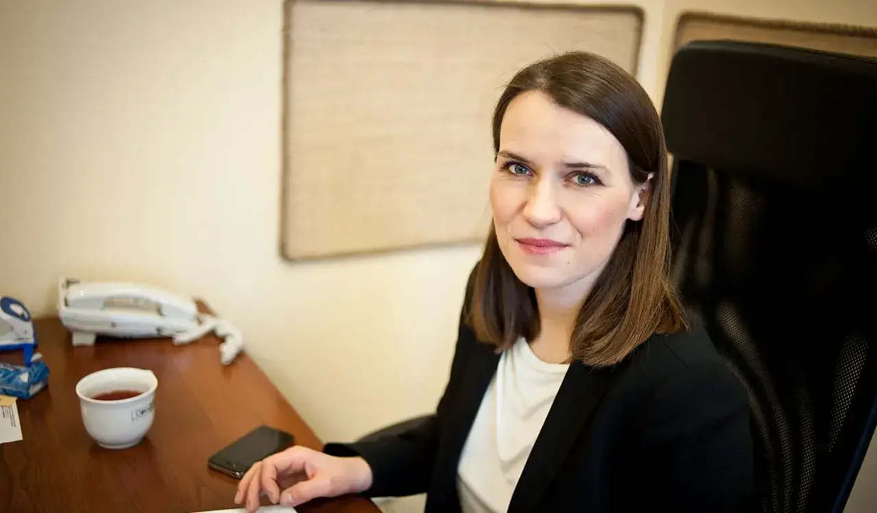 Agnieszka Pomaska, w biurze, z kubkiem herbaty i telefonem. Może wspomina rodziców?