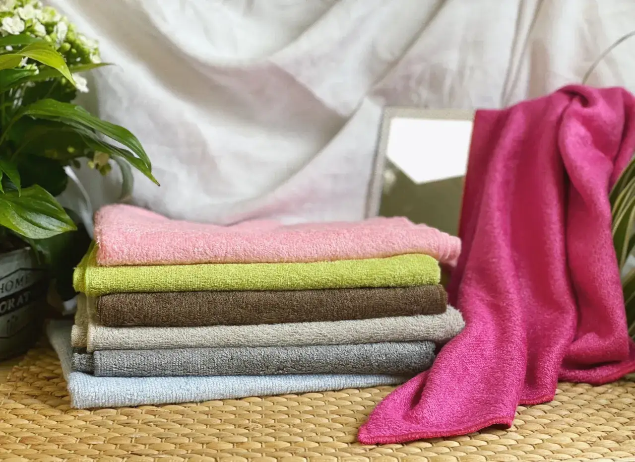 Pile de serviettes de bain aux couleurs pastel et vives, la matière douce invite à la détente.