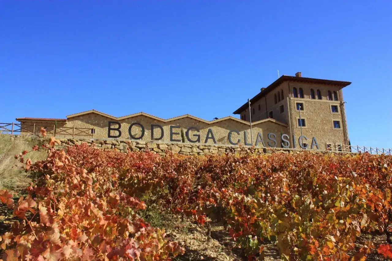 Bodega Classica en Haro, con viñedos de otoño en primer plano. Un lugar que ver si visitas la Rioja.