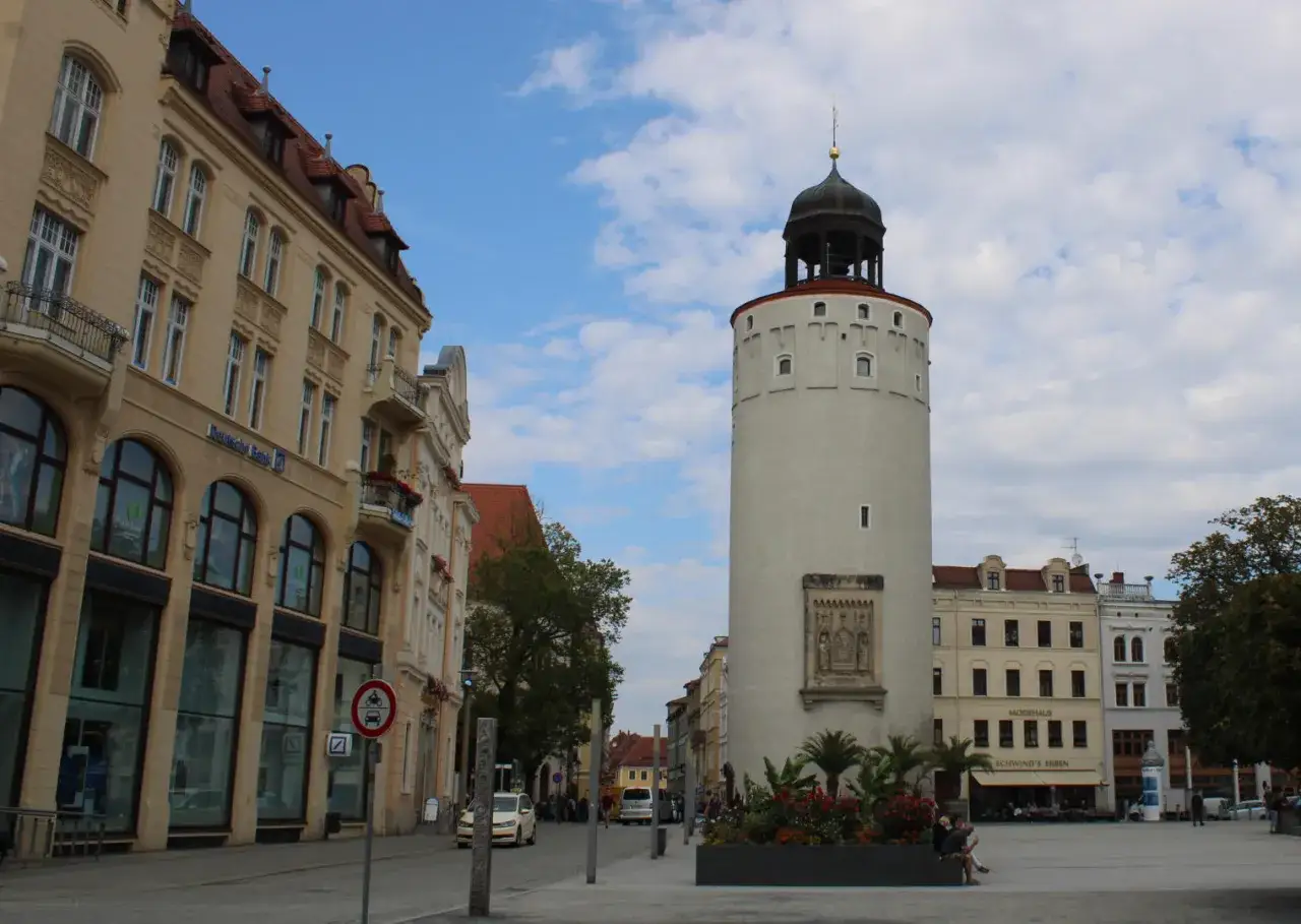 Der Reichenturm am Marienplatz G&ouml;rlitz ragt neben historischen Geb&auml;uden in den Himmel.