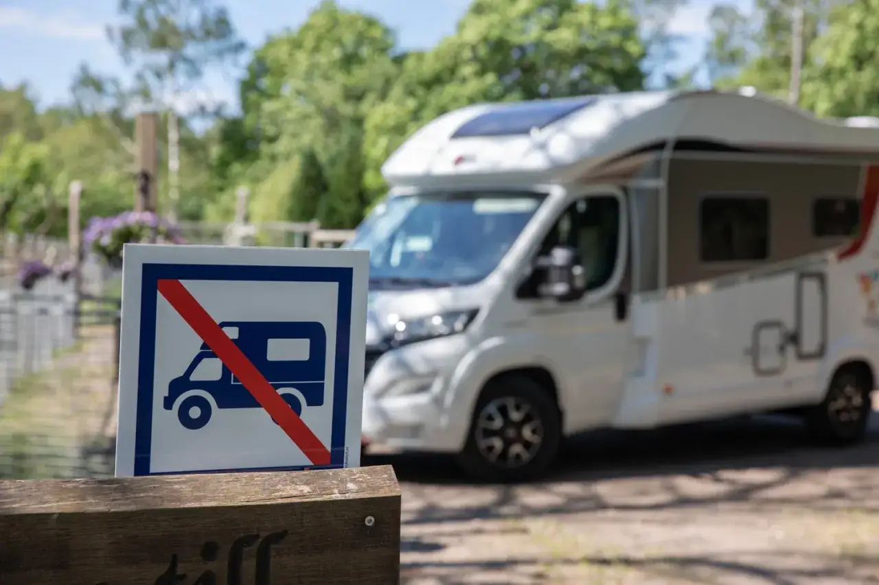 F&ouml;rbudsskylt f&ouml;r husbil. En vit husbil st&aring;r parkerad bakom skylten.