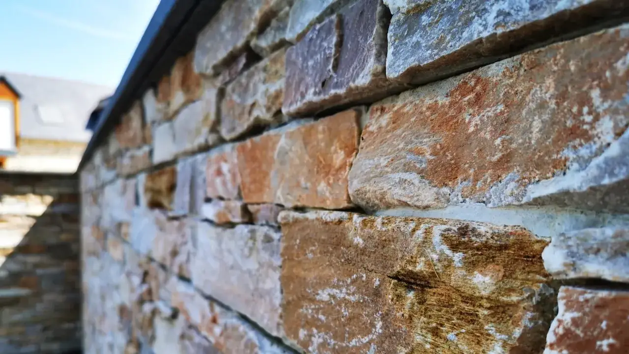 Gros plan sur une pose pierre de parement extérieur aux teintes chaudes et naturelles, créant une texture rustique et élégante.